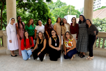 Descrição da imagem: foto de um grupo de 13 educadoras perfiladas e sorridentes posando para foto.